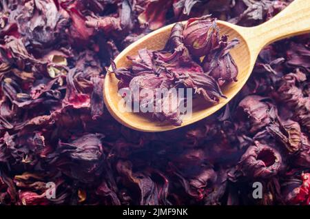 Top view of Dry Hibiscus petals in wooden spoon background closeup Stock Photo