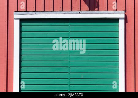 A green wooden door, on a red building in Littlehampton, West Sussex, UK Stock Photo