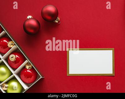 Holiday brand identity design and Christmas flatlay concept. White blank business card and xmas ornament and decoration on red p Stock Photo
