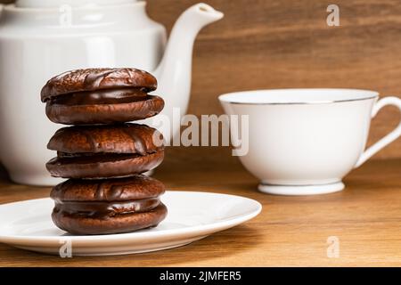 Closeup view stack of choco pie and a cup of hot tea. Stock Photo
