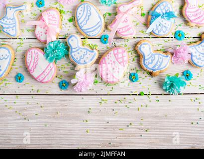 Homemade Easter cookies in shape of eggs chicken and rabbit on white wooden kitchen table flat lay view. Space for text Stock Photo
