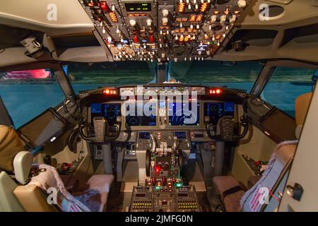 A view of the cockpit of a large commercial airplane a cockpit . Cockpit view of a commercial aircraft cruising Control panel in a plane cockpit. Stock Photo
