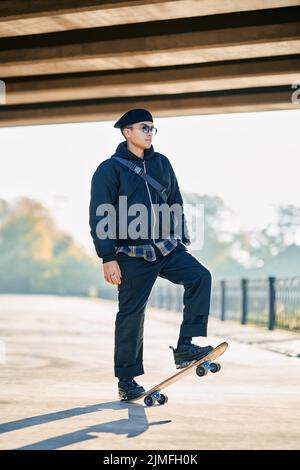 Skateboarder doing a trick on the street urban background Stock Photo