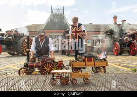 Kidderminster, Worcs, UK. 6th Aug, 2022. Steam enthusiast Michael Pryce shows off his pride and joy 1:3 scale miniature steam traction engine 'Smokey Joe' with Jim Parker at the Severn Valley Railway's Vintage Transport Extravaganza at Kidderminster, Worcestershire. The annual event has vintage motor vehicles as well as steam engines. Credit: Peter Lopeman/Alamy Live News Stock Photo