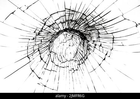 A crack on a broken glass mirror on a black background lines fragments bullet hole Stock Photo