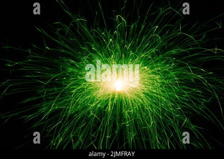 Sparkler, green sparks on a black background. Abstract photo of sparks, holiday lights. Stock Photo