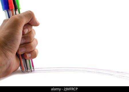 Multicolored pens in hand isolated on white background. Lines on white. Copy space. Stock Photo