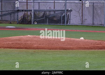 Empty baseball pitchers mound on a turf field looking from third base. Stock Photo