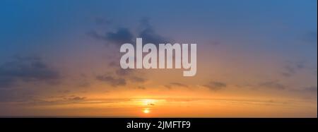Sunset panorama with blurred colorful sky and orange sun. Stock Photo