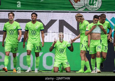 06 August 2022, Lower Saxony, Wolfsburg: Soccer, Bundesliga, VfL Wolfsburg - SV Werder Bremen, Matchday 1, Volkswagen Arena. Wolfsburg's Lukas Nmecha (center) celebrates after scoring the 1:0 goal. Photo: Swen Pförtner/dpa - IMPORTANT NOTE: In accordance with the requirements of the DFL Deutsche Fußball Liga and the DFB Deutscher Fußball-Bund, it is prohibited to use or have used photographs taken in the stadium and/or of the match in the form of sequence pictures and/or video-like photo series. Stock Photo