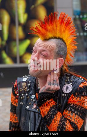 Blackpool, Lancashire, UK. 6th Aug 2022. The punk subculture, ideologies, fashion, with Mohican dyed hairstyles and colouring at the Punk Rebellion festival at The Winter Gardens. A protest against conventional attitudes and behaviour, a clash of anti-establishment cultures,  mohawks, safety pins and a load of attitude at the seaside town as punks attending the annual Rebellion rock music festival at the Winter Gardens come shoulder to shoulder with traditional holidaymakers.  Credit; MediaWorldImages/AlamyLiveNews Stock Photo