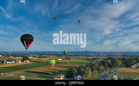 Aerial View of Many Hot Air Balloons Flying Across Rural Countryside Stock Photo