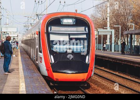 Intercity train at railroad station in Moscow region, passengers waiting on railway platform, Moscow, 31 Oct 2021 Stock Photo