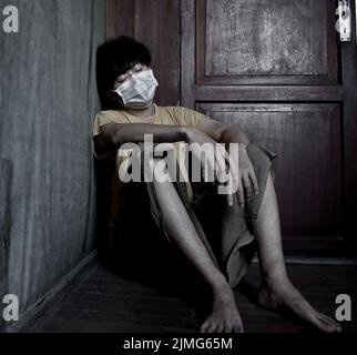Asian young man with face mask. Concept of burnout, tiredness, weakness or exhaustion. Stock Photo