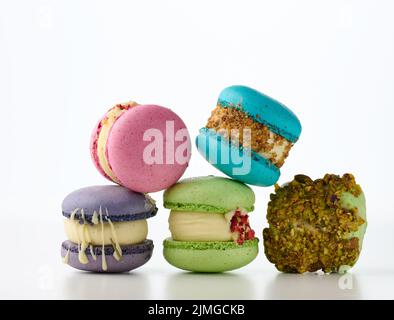 Round french cakes made from almond flour macarons on a white background. Raspberry, pistachio and lavender flavor Stock Photo