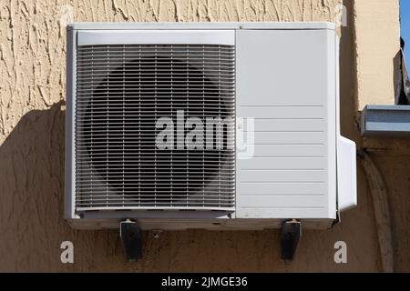 outdoor unit of a domestic air conditioner with a fan outside the building Stock Photo