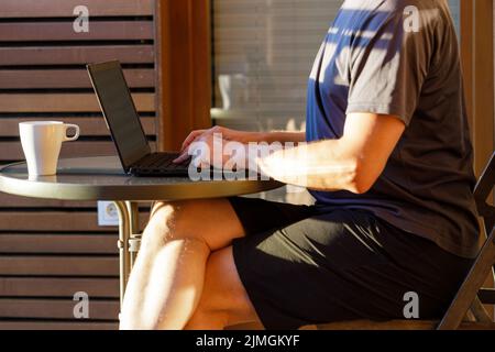 Working from home on the laptop. Wearing casual comfort outfit in home office. Stock Photo