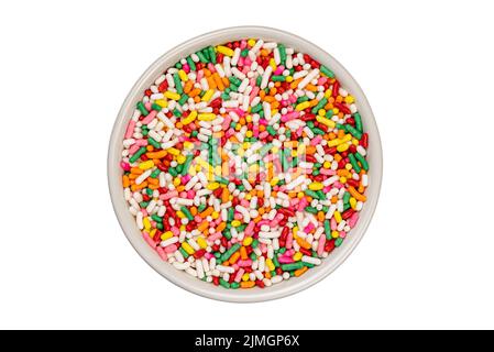 Top view of multicolored rainbow sugar sprinkles in white ceramic cup. Stock Photo