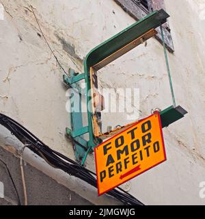 A broken yellow sign above an abandoned and derelict photography shop in madeira portugal the sign reads in english, picture per Stock Photo
