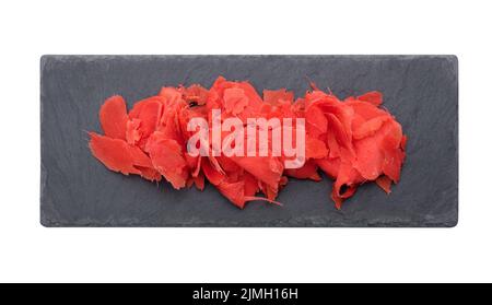 Pickled pink ginger on a black stone board, spice for sushi. White background Stock Photo