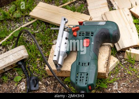 Electric jigsaw. Woodworking power tools. Wooden boards. Workshop. Stock Photo