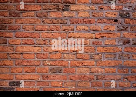 Old brick wall background, brick wall texture. Old broken brick, cement joints, closeup. crumbles with age. Stock Photo