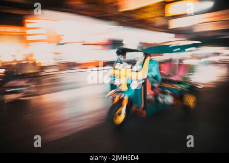 Blurred tuk tuk in traffic in Bangkok Stock Photo