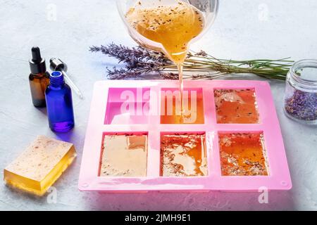 Soap making at home. Liquid glycerin with the additives of peels and flower  buds poured into a mould, with essential oils Stock Photo - Alamy