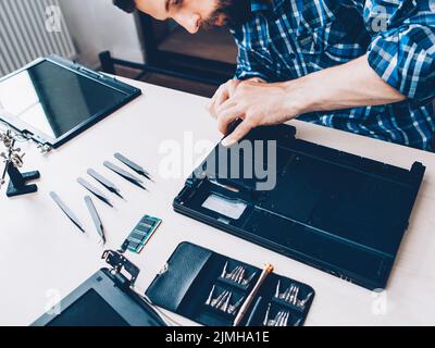 tech support engineer disassembling laptop tools Stock Photo