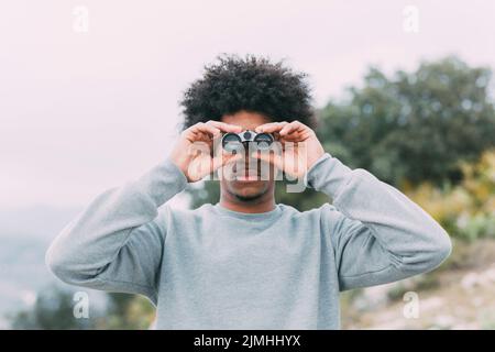 Man looking through binoculars Stock Photo