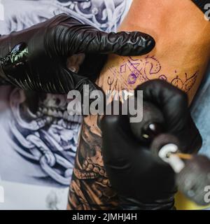 Hands gloves doing tattoo Stock Photo