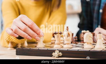 Close up young woman playing chess board game Stock Photo