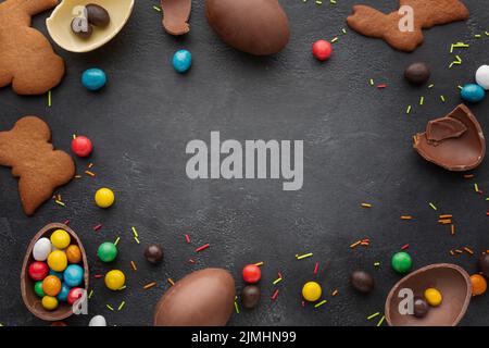 Top view chocolate easter eggs with candy cookies frame Stock Photo