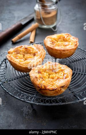 Traditional Portuguese pasteis de nata as close-up on a cooling rack Stock Photo
