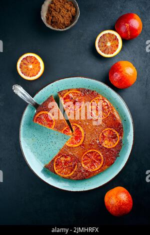 Modern style traditional Italian blood orange ricotta pie with fruits and almonds served as top view on a Nordic design plate wi Stock Photo
