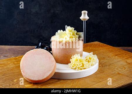 Traditional tete de moine aged mountain cheese of the Alps served with  grapes and walnuts wooden design board with copy space Stock Photo - Alamy