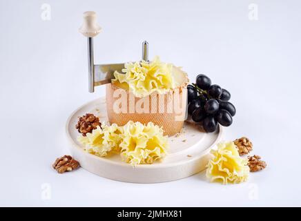 Traditional tete de moine aged mountain cheese of the Alps served with  grapes and walnuts wooden design board with copy space Stock Photo - Alamy