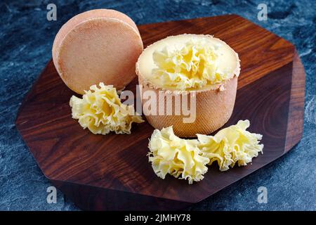 https://l450v.alamy.com/450v/2jmhy78/traditional-tete-de-moine-aged-mountain-cheese-of-the-alps-served-on-a-wooden-design-board-2jmhy78.jpg