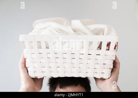 Front view person holding laundry basket head Stock Photo