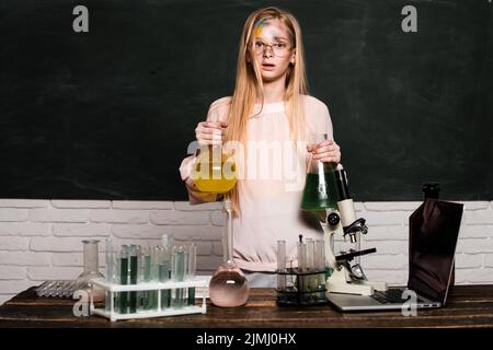 Funny little school child doing experiments in the laboratory. Explosion in the lab. Little girl scientist in the laboratory. Chemical experiment Stock Photo