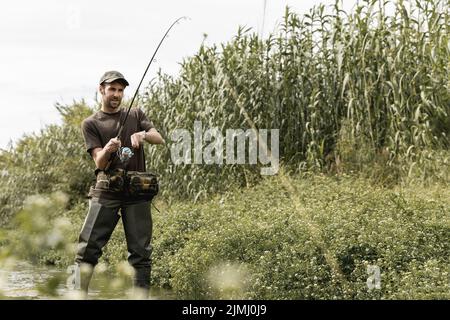 Senior man catching fish. Activity and hobby. Fishing freshwater