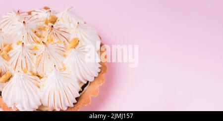 Close up lemon tart with italian meringue pink backdrop Stock Photo
