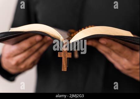 Front view person with holy book rosary Stock Photo