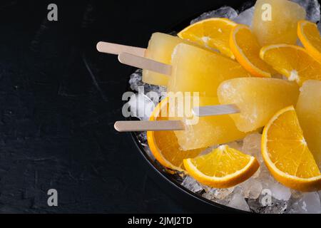 Fruit orange ice lolly and slices of orange. Top view. Copy space Stock Photo