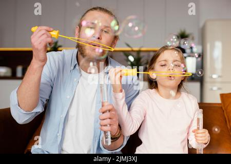 Front view father daughter playing with soap bubbles Stock Photo