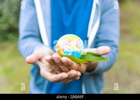 Man holding sphere palm hand with leaf Stock Photo
