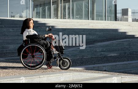 Side view woman wheelchair street with copy space Stock Photo