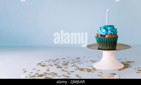Candle cupcake cakestand against blue background Stock Photo