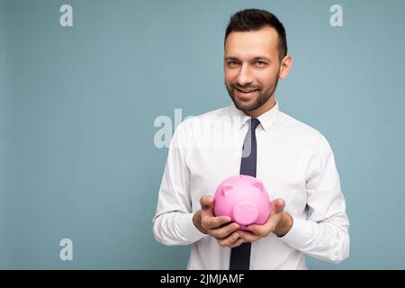 Photo of positive self-confident young handsome brunet unshaven male businessman with beard wearing casual white shirt and tie i Stock Photo