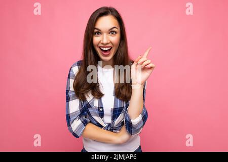 Photo portrait of young beautiful shocked, amazed shocked brunette woman in trendy blue and white shirt. Female person posing is Stock Photo